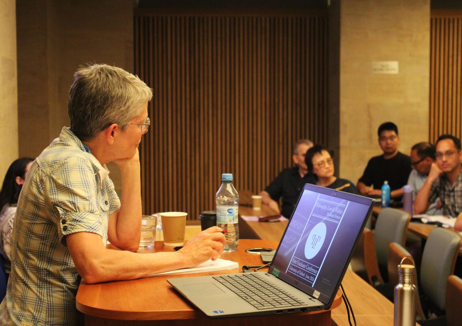 A speaker presenting their work at a PLP colloquium
