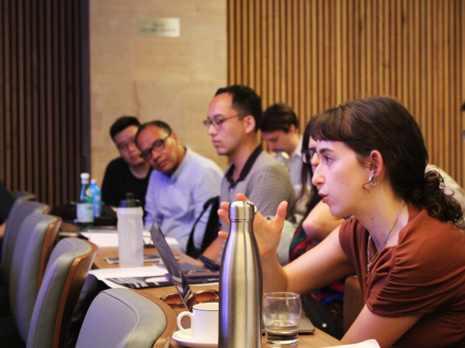 Graduate students and faculty in discussion around a seminar table